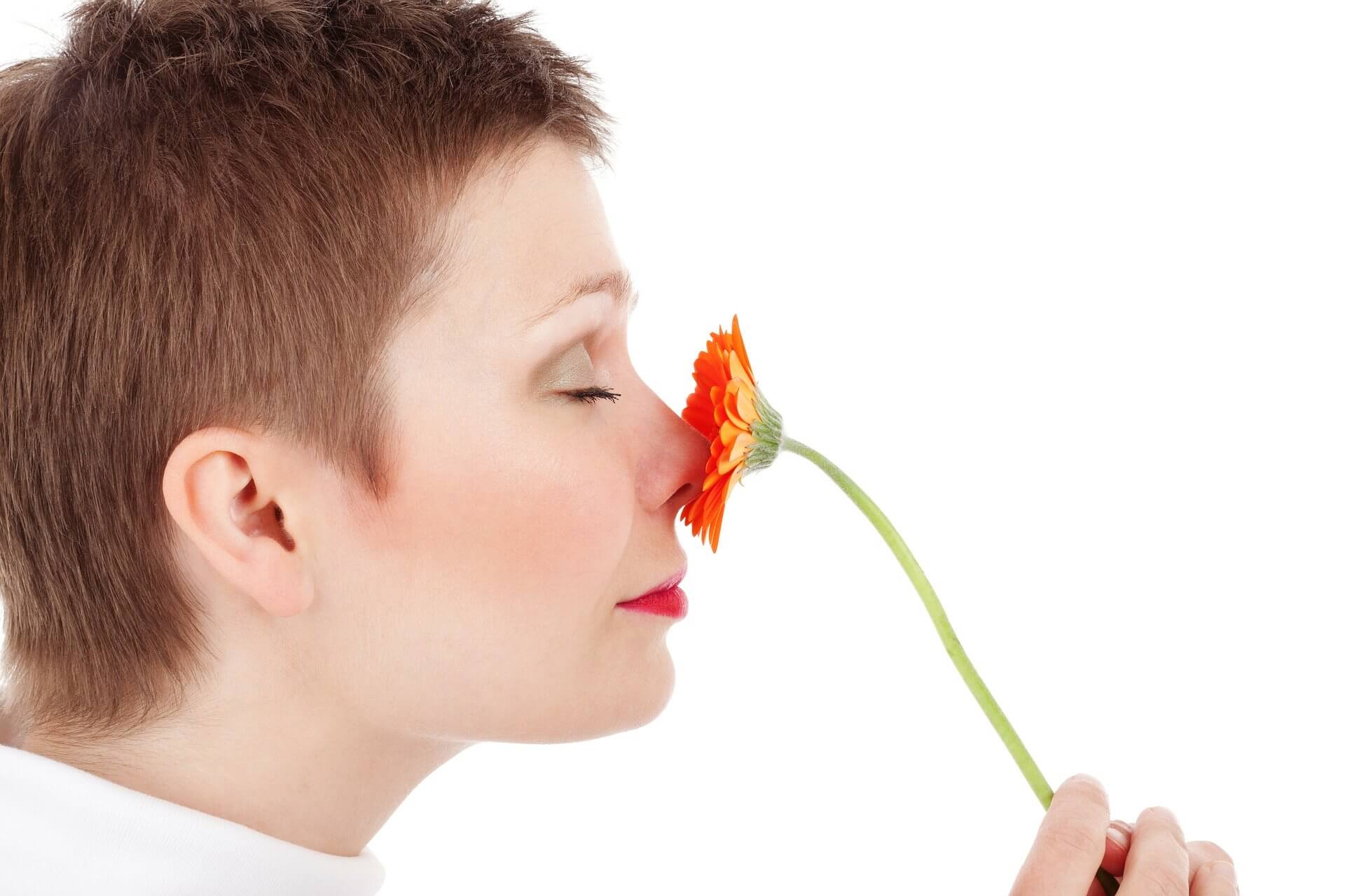 Frau riecht an Blume