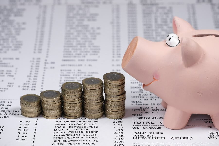 Sparschwein auf Rechnungen mit Geld zum Heizkosten sparen
